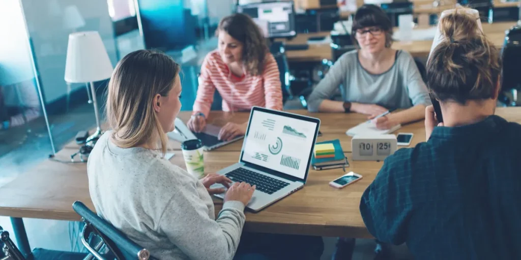 Why partner with Amplified Audience Partners - meeting table with employees
